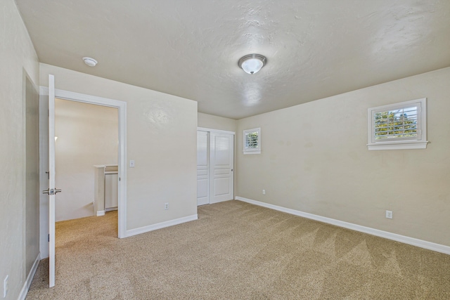 unfurnished bedroom featuring carpet, a closet, and baseboards