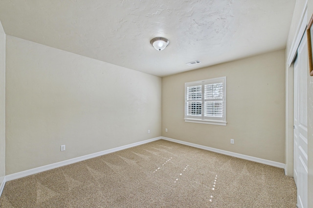 unfurnished bedroom featuring baseboards, visible vents, carpet floors, and a closet