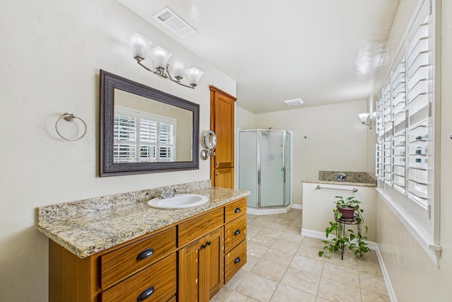 bathroom featuring visible vents, a stall shower, a healthy amount of sunlight, and vanity