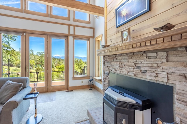 carpeted living area featuring baseboards and a high ceiling