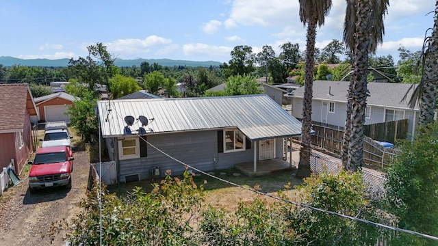 3169 Veda St, Redding, CA 96001 - rear view of house with metal roof, a mountain view, and driveway