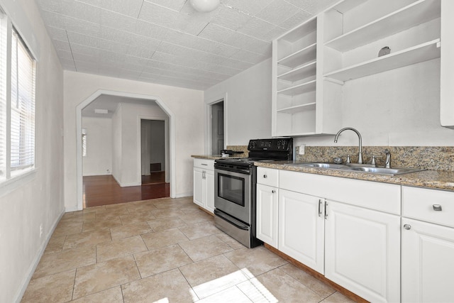 3169 Veda St, Redding, CA 96001 - kitchen with electric range, open shelves, a sink, arched walkways, and white cabinets