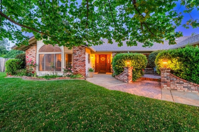 3301 Bridger Dr, Redding, CA 96002 - view of front facade featuring brick siding and a front lawn