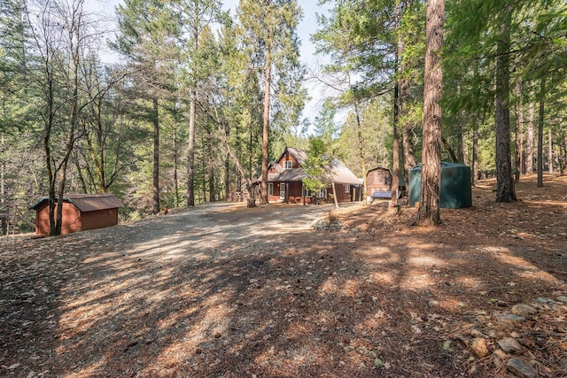 view of yard featuring an outdoor structure and a shed