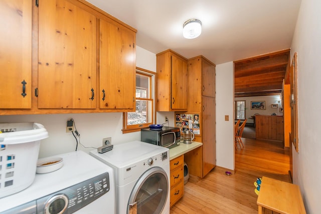 clothes washing area with washing machine and clothes dryer, laundry area, and light wood-style floors