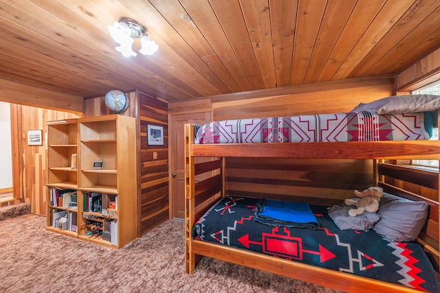 carpeted bedroom featuring wood ceiling and wooden walls