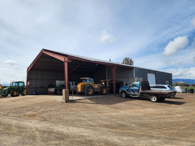 view of parking / parking lot with a pole building and dirt driveway