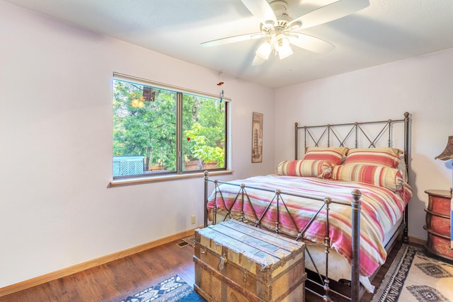 bedroom featuring ceiling fan, baseboards, visible vents, and wood finished floors