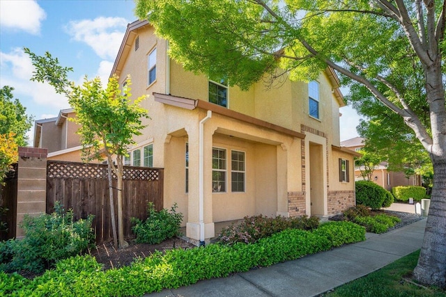 view of side of home with fence and stucco siding