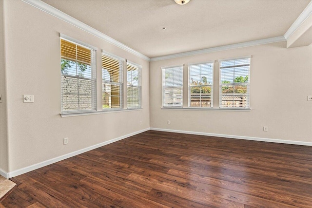 spare room with baseboards, ornamental molding, and wood finished floors