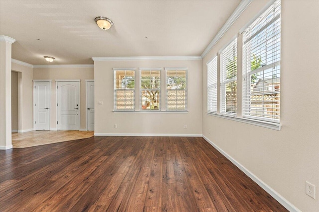 empty room with baseboards, ornamental molding, and dark wood-style flooring