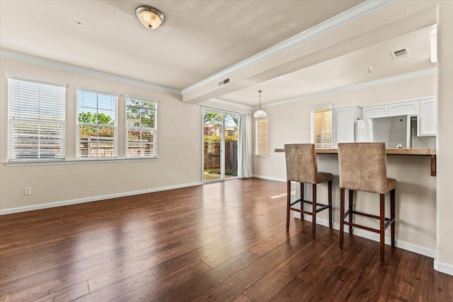 interior space with visible vents, ornamental molding, and dark wood finished floors