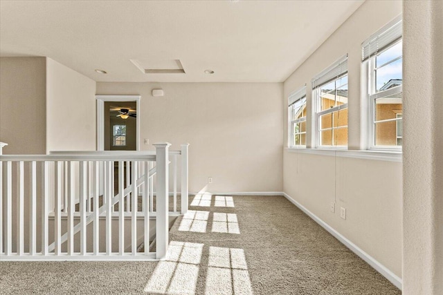 hall with baseboards, carpet flooring, attic access, and an upstairs landing