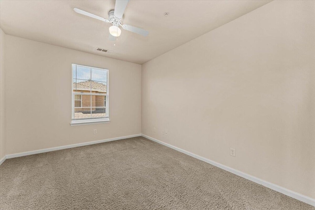 spare room with carpet floors, baseboards, visible vents, and ceiling fan