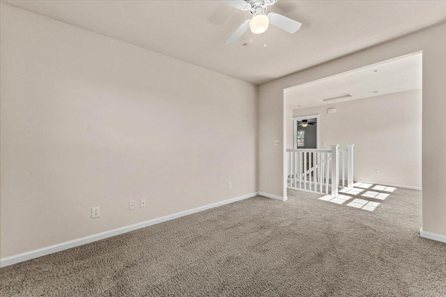 carpeted empty room featuring a ceiling fan and baseboards