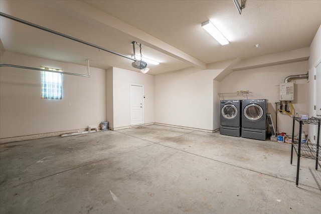 garage with tankless water heater, a garage door opener, and washer and dryer
