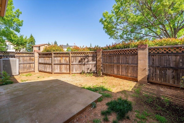 view of yard with a fenced backyard, a patio, and cooling unit