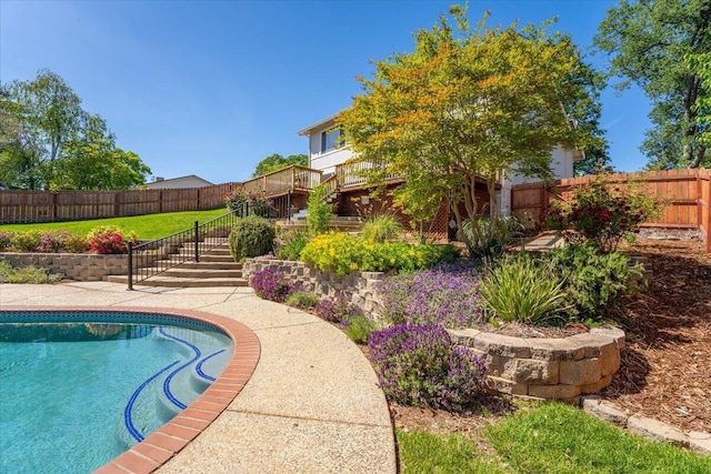 view of pool featuring a wooden deck, a fenced backyard, stairs, a fenced in pool, and a lawn