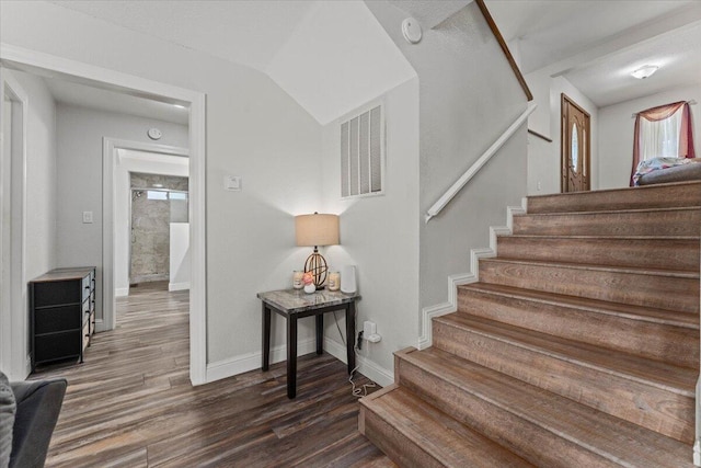 staircase with visible vents, baseboards, and wood finished floors