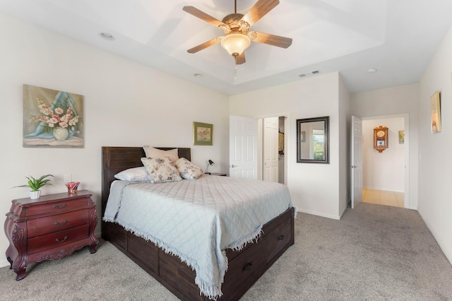 carpeted bedroom featuring visible vents, recessed lighting, ceiling fan, and a tray ceiling