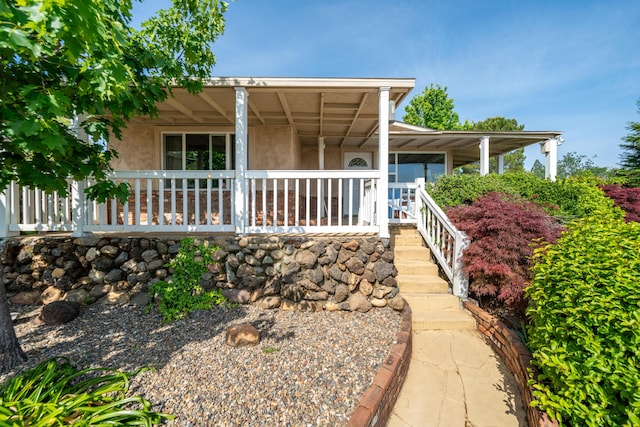 view of front of house with covered porch and stucco siding