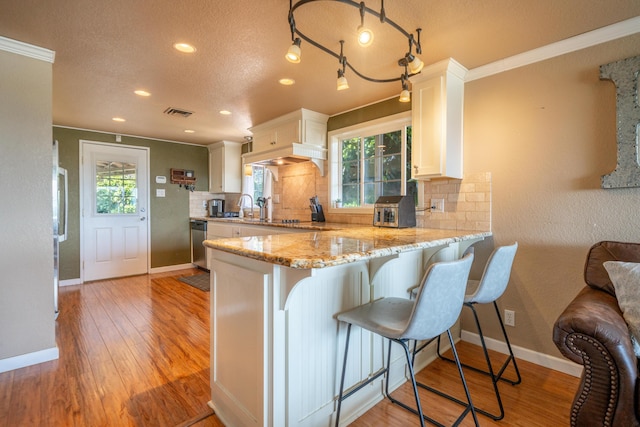 kitchen with stainless steel dishwasher, white cabinetry, baseboards, and tasteful backsplash