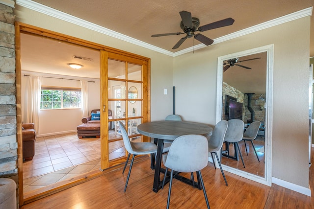 dining space with crown molding, ceiling fan, visible vents, and wood finished floors