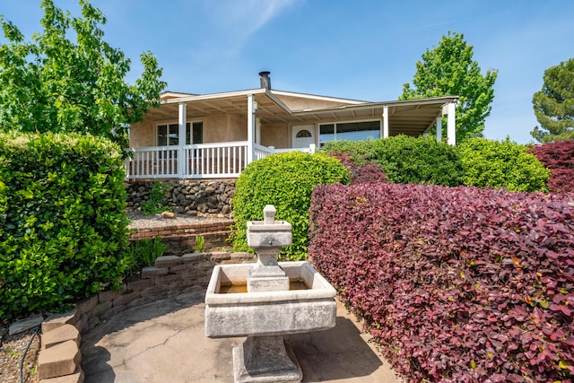 view of front of house featuring covered porch and stucco siding