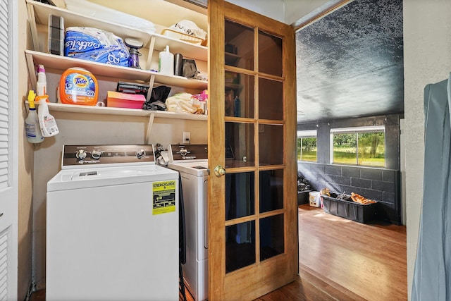 laundry area with separate washer and dryer and wood finished floors
