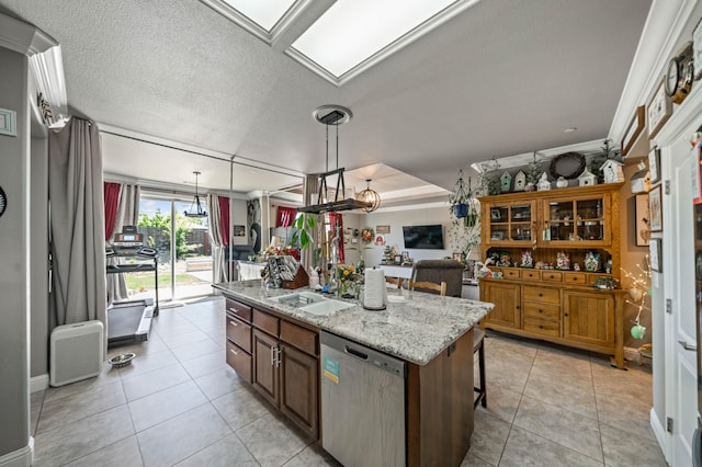 kitchen with stainless steel dishwasher, a kitchen island with sink, light tile patterned flooring, a kitchen breakfast bar, and light stone counters