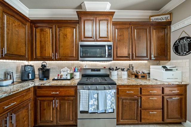 kitchen with light stone counters, ornamental molding, and stainless steel appliances