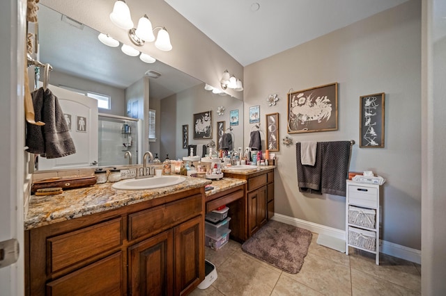bathroom featuring vanity, tile patterned floors, baseboards, and a stall shower