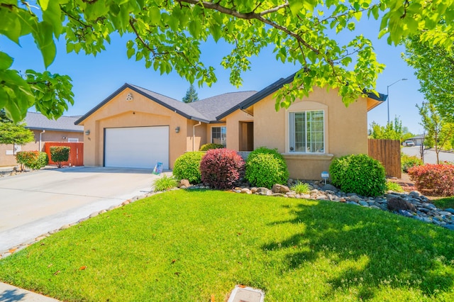 ranch-style house featuring an attached garage, fence, a front yard, and stucco siding