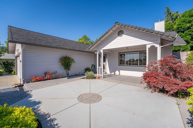 ranch-style home with a porch and a chimney