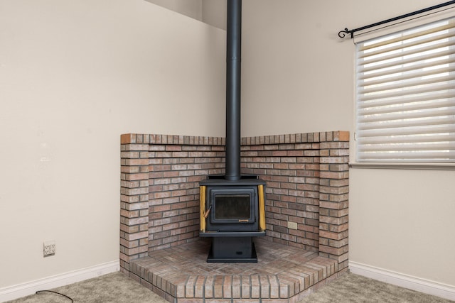 details with baseboards, a wood stove, and carpet