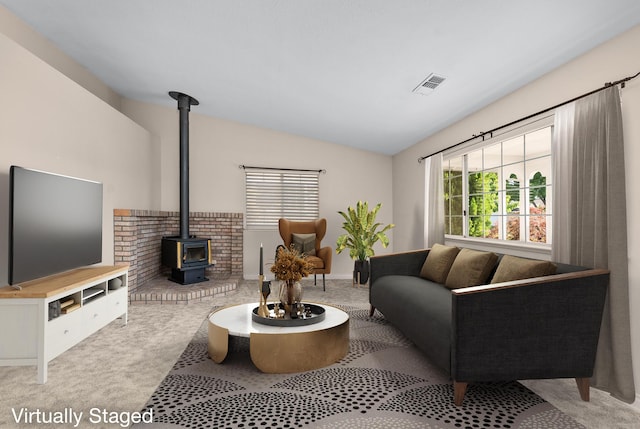 carpeted living room with visible vents, a wood stove, and lofted ceiling