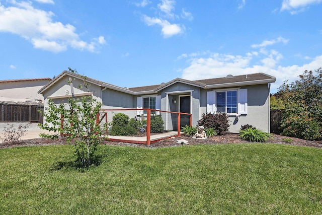 ranch-style home with a garage, stucco siding, a front lawn, and fence