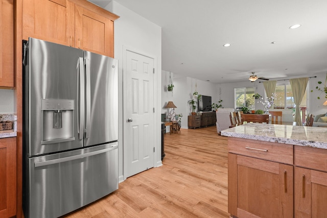 kitchen featuring a ceiling fan, open floor plan, stainless steel refrigerator with ice dispenser, light wood-type flooring, and recessed lighting