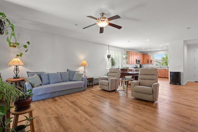 living area featuring a ceiling fan, light wood-style flooring, recessed lighting, and plenty of natural light
