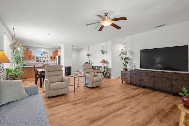 living room with a ceiling fan, recessed lighting, light wood-style floors, and visible vents