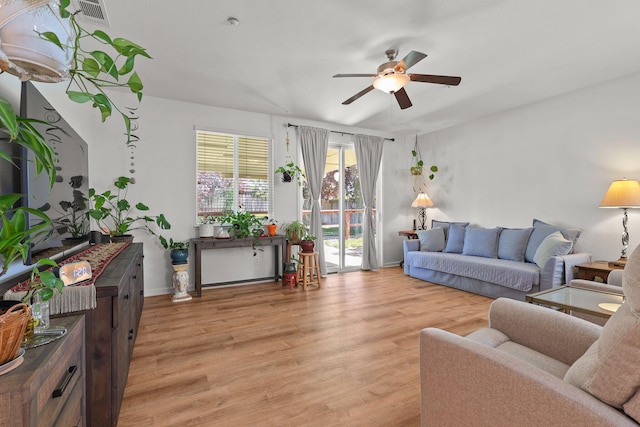 living area featuring ceiling fan, light wood-style flooring, baseboards, and visible vents
