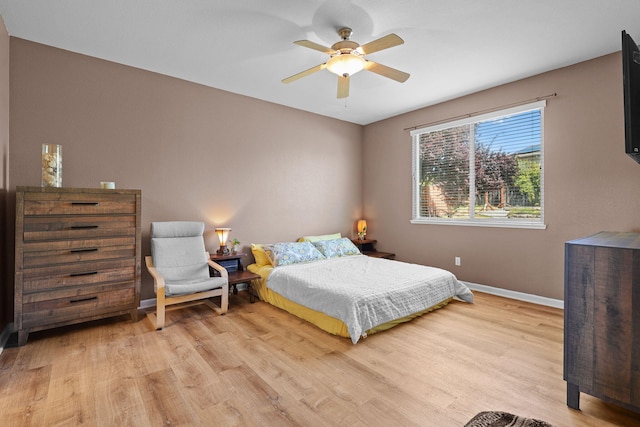 bedroom with light wood-style flooring, baseboards, and ceiling fan