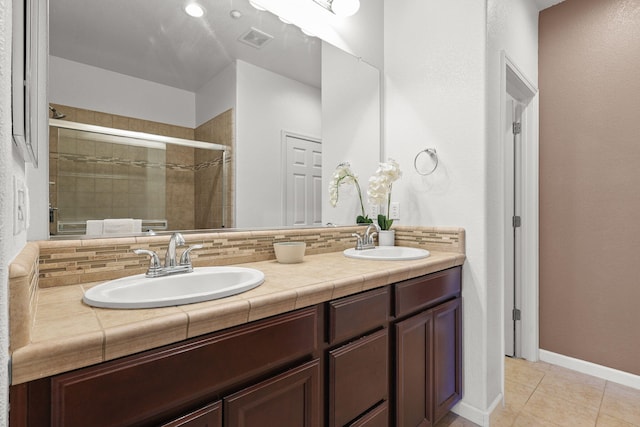 full bathroom with visible vents, tile patterned flooring, a shower stall, and a sink