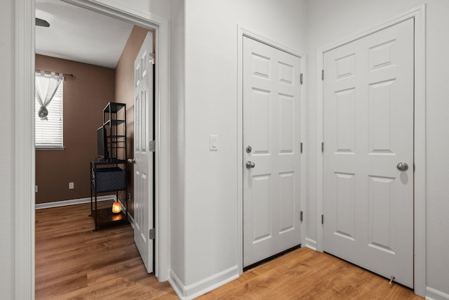 foyer entrance with light wood finished floors and baseboards