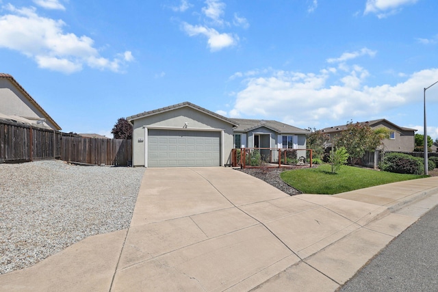 single story home featuring driveway, fence, an attached garage, stucco siding, and a front lawn
