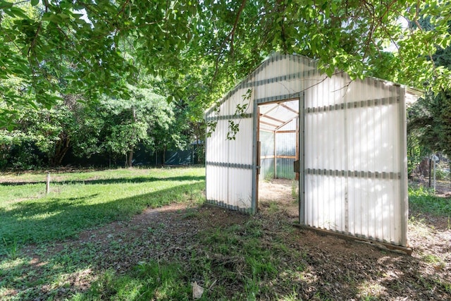 view of greenhouse with a lawn