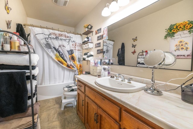 bathroom featuring shower / bath combo with shower curtain, visible vents, and vanity