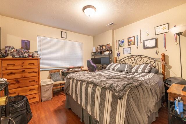 bedroom with visible vents and wood finished floors