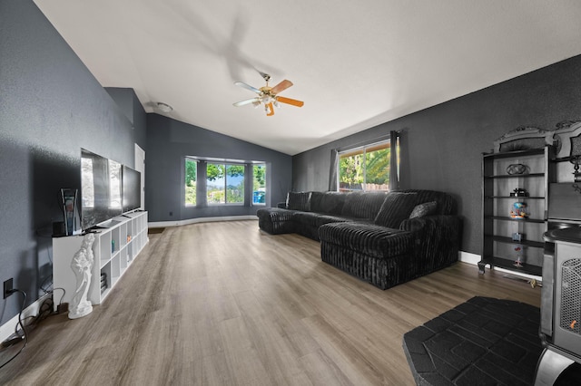 living room featuring baseboards, ceiling fan, vaulted ceiling, and wood finished floors