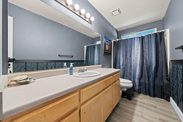 full bathroom featuring visible vents, curtained shower, wood finished floors, vanity, and toilet